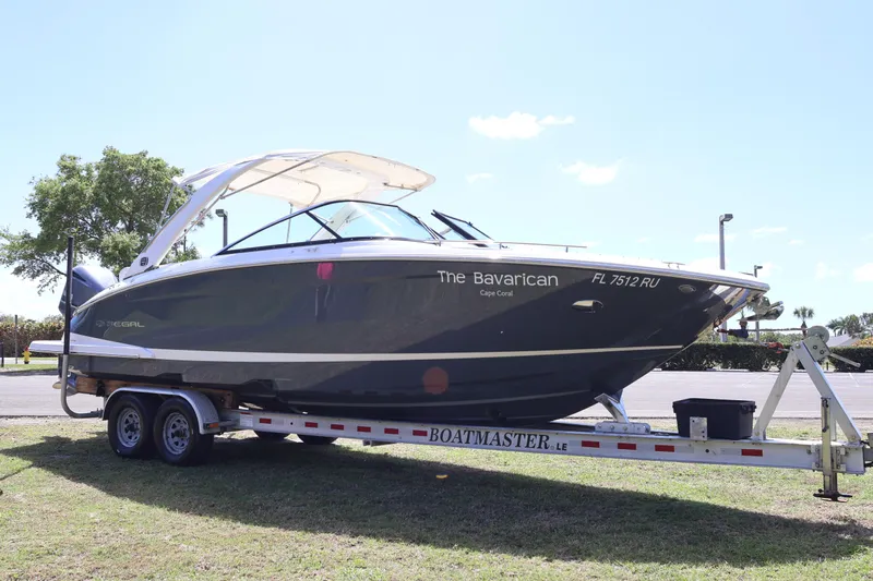  Yacht Photos Pics 2019 Regal 29 OBX boat on trailer, labeled "The Bavarican," parked outdoors.