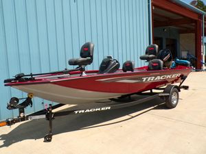 2025 Tracker Pro Team 175 TF® fishing boat on trailer, parked outside a blue building.