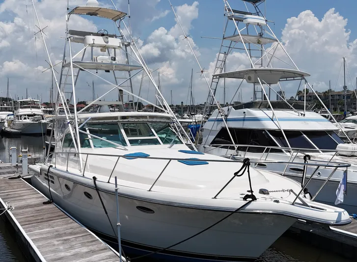 Hoggtide Two Yacht Photos Pics 1998 Tiara Yachts 4100 Open docked at a marina on a sunny day.