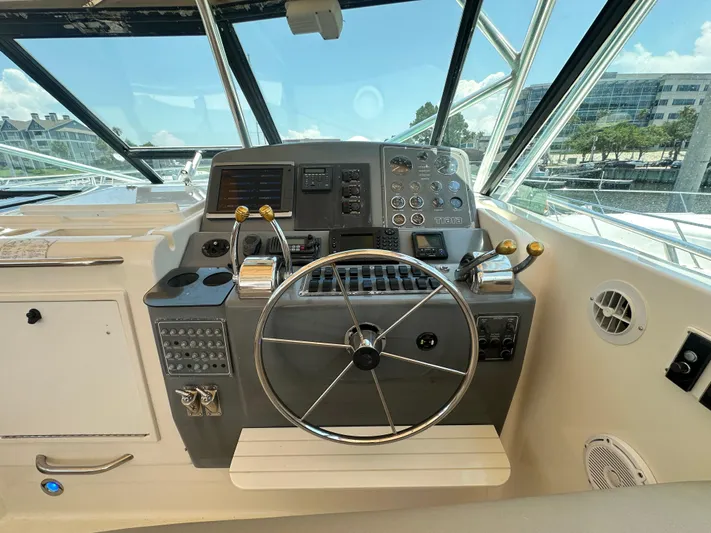 Hoggtide Two Yacht Photos Pics Helm of a 1998 Tiara Yachts 4100 Open with steering wheel and control panel.