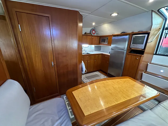 Hoggtide Two Yacht Photos Pics 1998 Tiara Yachts 4100 Open interior with kitchen, dining area, and wooden cabinetry.