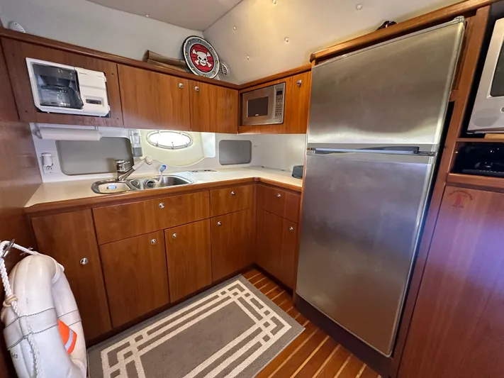 Hoggtide Two Yacht Photos Pics 1998 Tiara Yachts 4100 Open kitchen with stainless steel appliances and wooden cabinetry.