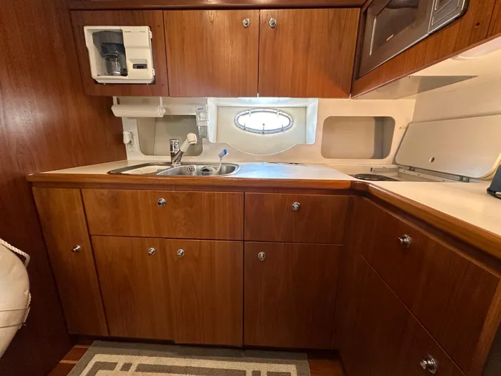 Hoggtide Two Yacht Photos Pics 1998 Tiara Yachts 4100 Open galley with wooden cabinets and stainless steel sink.