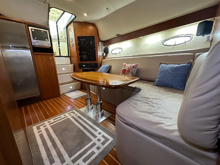 Hoggtide Two Yacht Photos Pics 1998 Tiara Yachts 4100 Open interior with cozy seating, wooden table, and modern amenities.