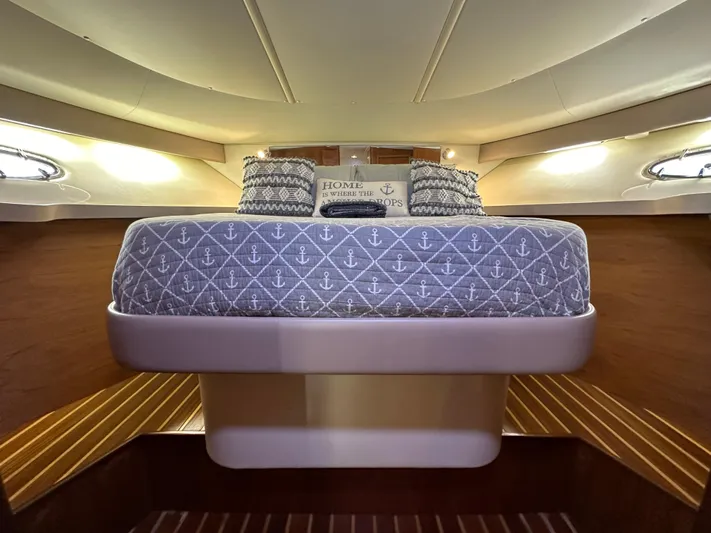 Hoggtide Two Yacht Photos Pics 1998 Tiara Yachts 4100 Open cabin with bed and nautical-themed bedding.