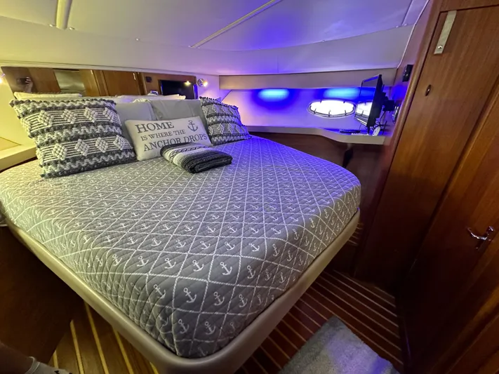 Hoggtide Two Yacht Photos Pics Luxurious bedroom interior of 1998 Tiara Yachts 4100 Open with nautical-themed bedding.