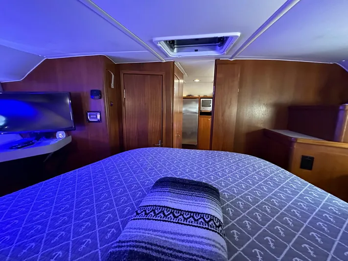 Hoggtide Two Yacht Photos Pics 1998 Tiara Yachts 4100 Open interior cabin with bed, TV, and kitchenette.