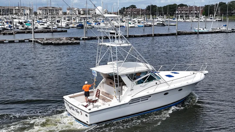 Hoggtide Two Yacht Photos Pics 1998 Tiara Yachts 4100 Open cruising in a marina with numerous docked boats.