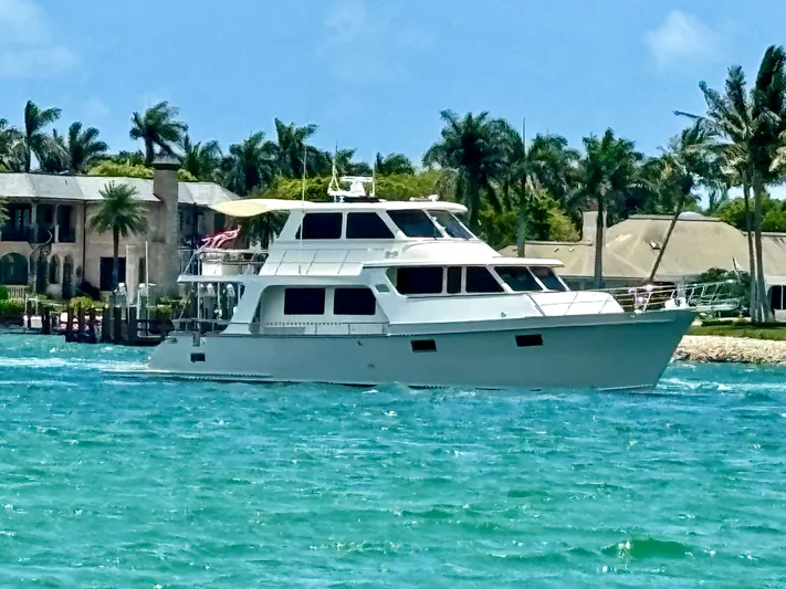 Forever Fun Yacht Photos Pics 2018 Marlow 53E CB yacht cruising in tropical waters near luxury waterfront homes.