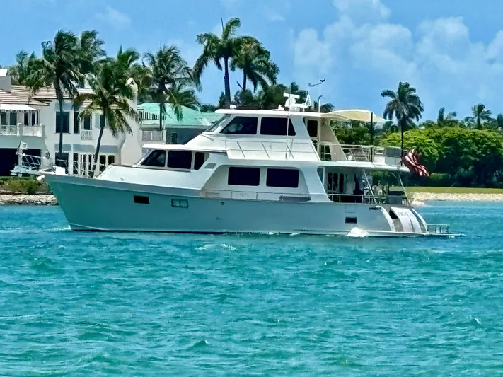 Forever Fun Yacht Photos Pics 2018 Marlow 53E CB yacht cruising on turquoise waters near palm-lined shore.