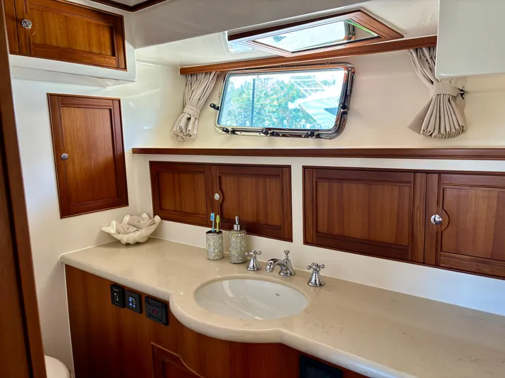 Forever Fun Yacht Photos Pics Luxurious Marlow 53E CB 2018 yacht bathroom with wooden cabinets and elegant fixtures.