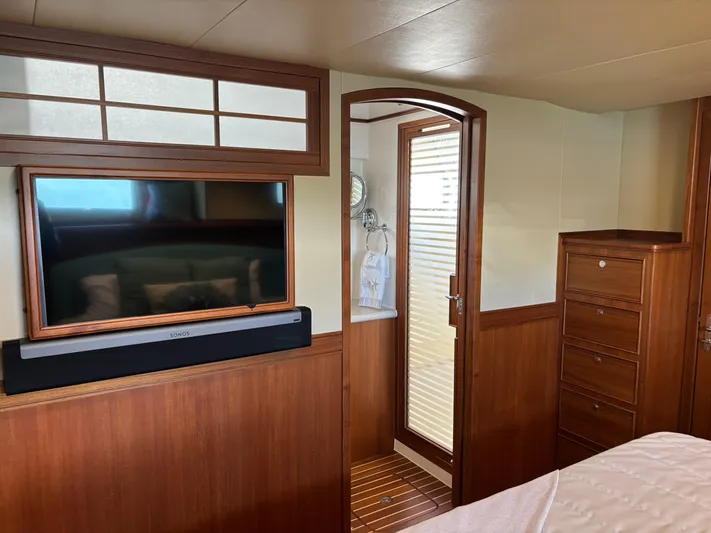 Forever Fun Yacht Photos Pics Luxurious Marlow 53E CB 2018 yacht interior with TV, wooden cabinetry, and elegant door.