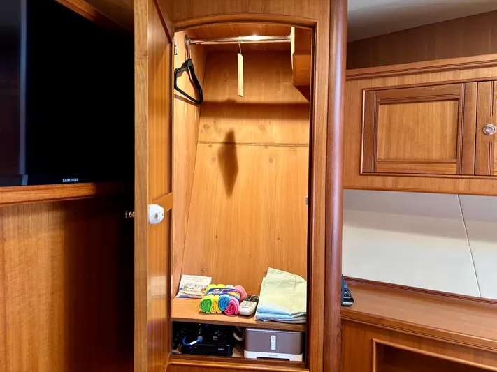 Forever Fun Yacht Photos Pics Wooden closet interior on a 2018 Marlow 53E CB yacht, with shelves and hangers.