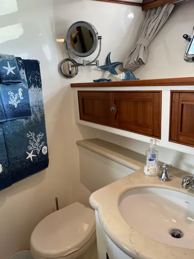 Forever Fun Yacht Photos Pics Luxurious Marlow 53E CB 2018 yacht bathroom with elegant wood cabinetry and nautical decor.