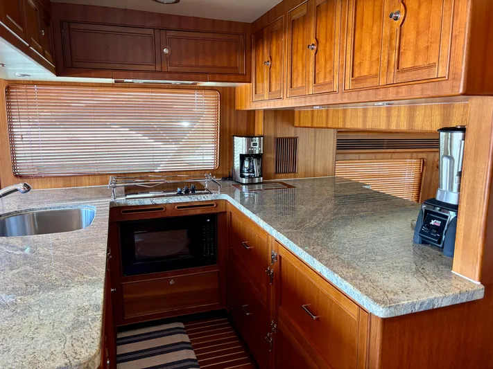 Forever Fun Yacht Photos Pics Luxurious Marlow 53E CB 2018 yacht kitchen with wooden cabinets and granite countertops.