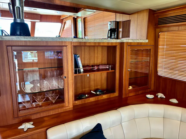 Forever Fun Yacht Photos Pics Luxurious Marlow 53E CB yacht interior with wooden cabinetry and glassware, 2018 model.