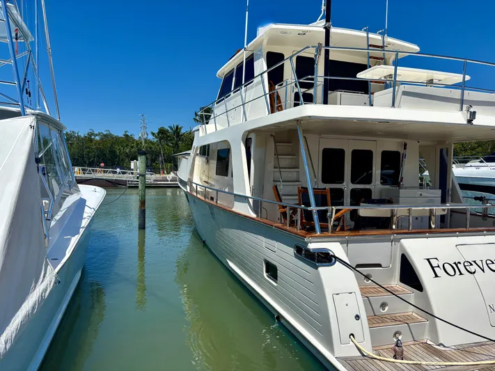 Forever Fun Yacht Photos Pics 2018 Marlow 53E CB yacht docked in a marina under clear blue skies.