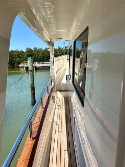 Forever Fun Yacht Photos Pics Side deck of 2018 Marlow 53E CB yacht with wooden flooring and railing.