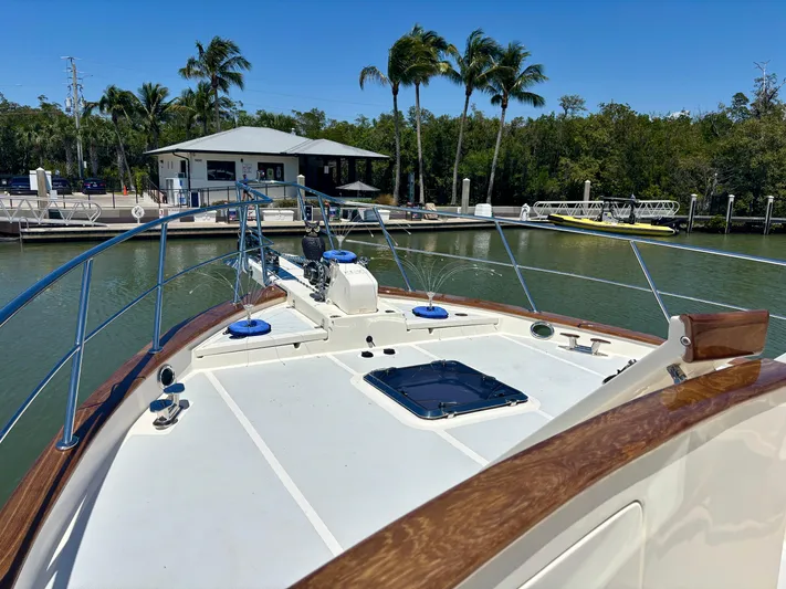Forever Fun Yacht Photos Pics Bow view of 2018 Marlow 53E CB yacht docked near a marina with palm trees.