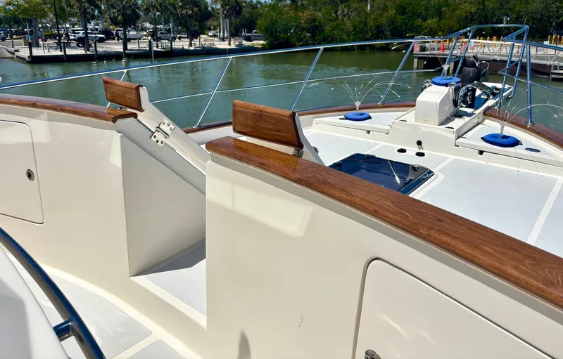 Forever Fun Yacht Photos Pics Luxury Marlow 53E CB yacht deck with wood accents, docked by a scenic waterfront.