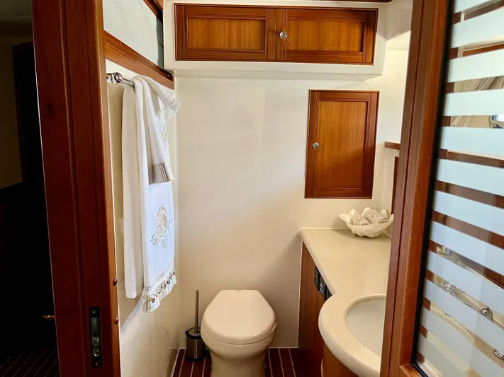 Forever Fun Yacht Photos Pics Luxurious Marlow 53E CB 2018 yacht bathroom with wooden cabinetry and modern fixtures.