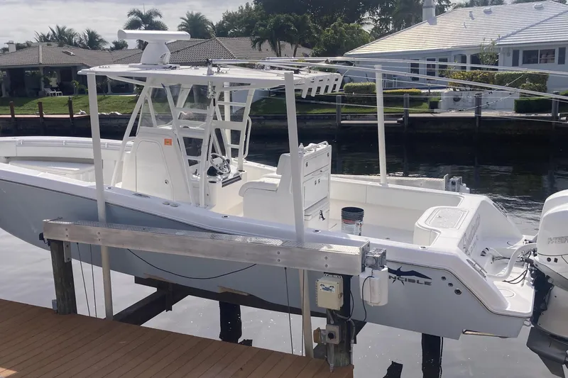 Sandtastic Yacht Photos Pics 2020 Invincible 33 Open Fisherman boat docked by waterfront homes.