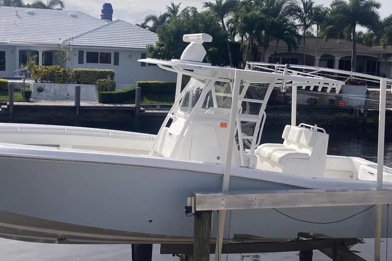 Sandtastic Yacht Photos Pics 2020 Invincible 33 Open Fisherman boat docked near waterfront homes.