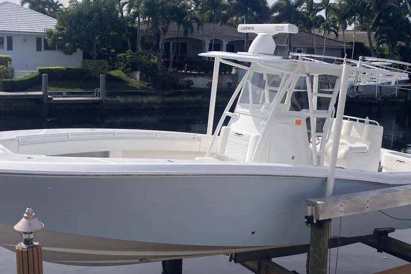 Sandtastic Yacht Photos Pics 2020 Invincible 33 Open Fisherman boat docked by waterfront homes.