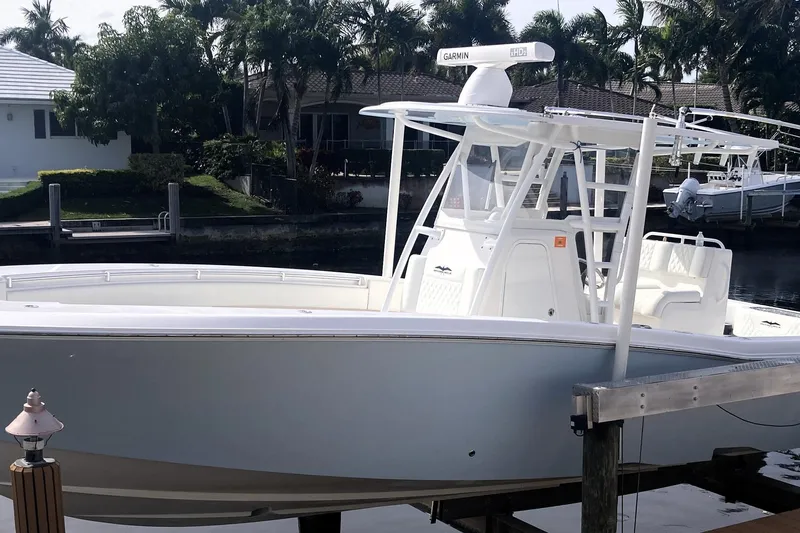 Sandtastic Yacht Photos Pics 2020 Invincible 33 Open Fisherman boat docked near waterfront homes.