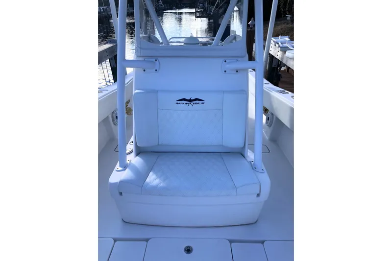 Sandtastic Yacht Photos Pics 2020 Invincible 33 Open Fisherman boat seat with logo, docked by water.
