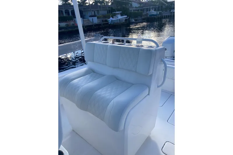 Sandtastic Yacht Photos Pics 2020 Invincible 33 Open Fisherman boat with white cushioned seating by the water.
