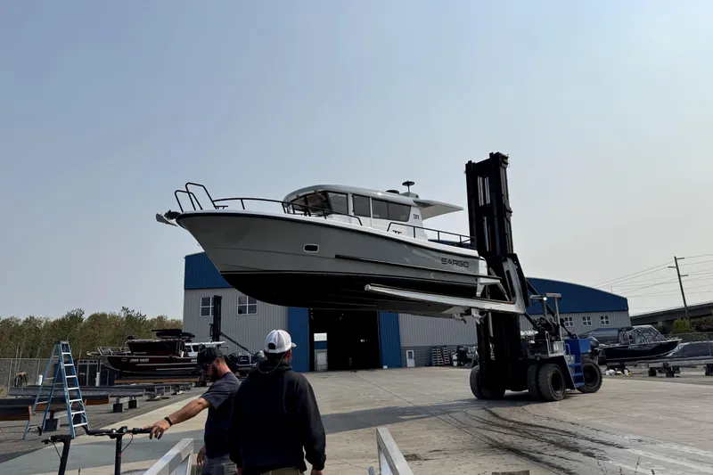  Yacht Photos Pics 2025 Sargo 31OB boat lifted by forklift in a shipyard setting.