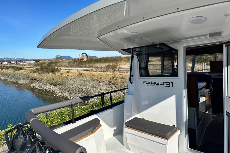  Yacht Photos Pics 2025 Sargo 31OB boat docked by a scenic riverside.