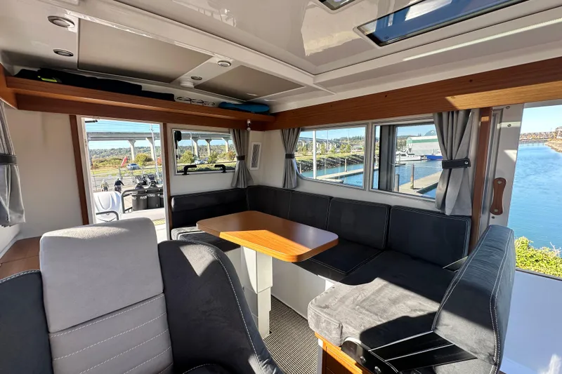 Yacht Photos Pics Interior of 2025 Sargo 31OB boat with seating and table, dockside view.