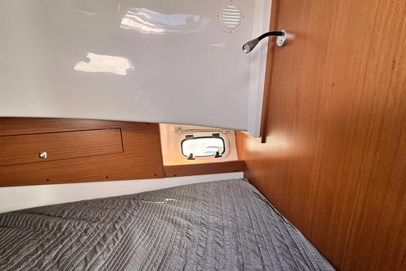  Yacht Photos Pics Interior cabin of 2025 Sargo 31OB boat with wooden paneling and a cozy bed.
