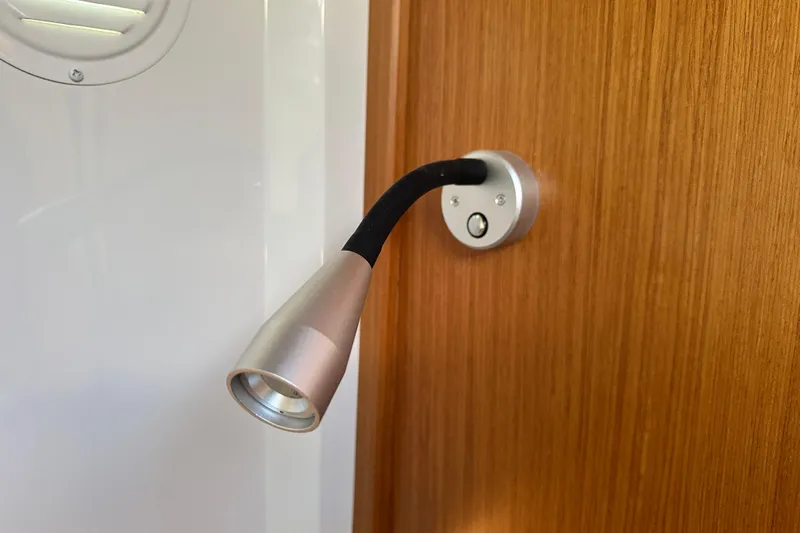  Yacht Photos Pics Adjustable reading light on Sargo 31OB 2025 boat, mounted on wooden panel.