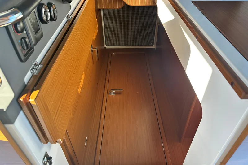  Yacht Photos Pics Interior view of 2025 Sargo 31OB boat, featuring wooden cabinetry and control panel.