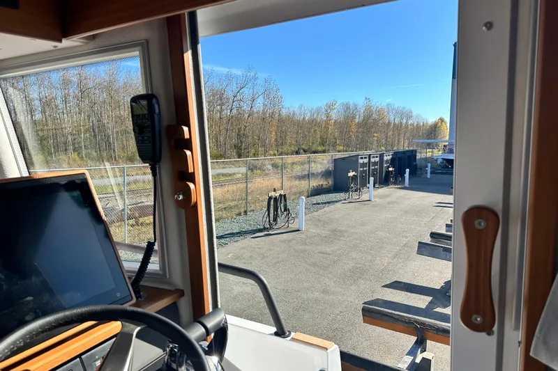  Yacht Photos Pics Interior view of 2025 Sargo 31OB boat, showing dashboard and outdoor marina scene.