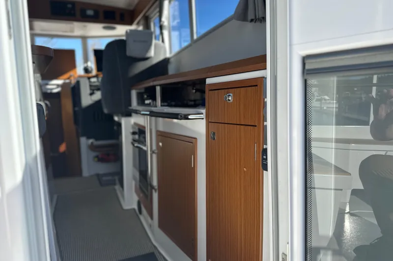  Yacht Photos Pics Interior view of 2025 Sargo 31OB boat, featuring modern kitchen cabinetry and seating.