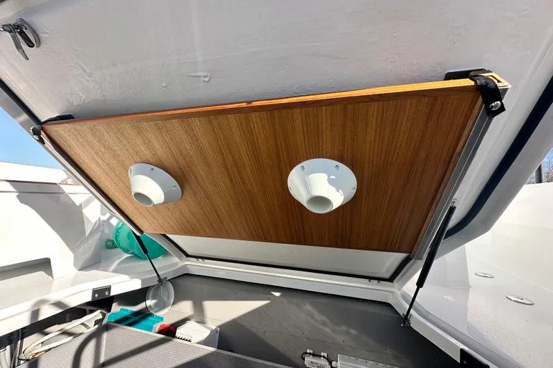  Yacht Photos Pics Open storage compartment in 2025 Sargo 31OB boat, featuring wooden panel and ventilation outlets.