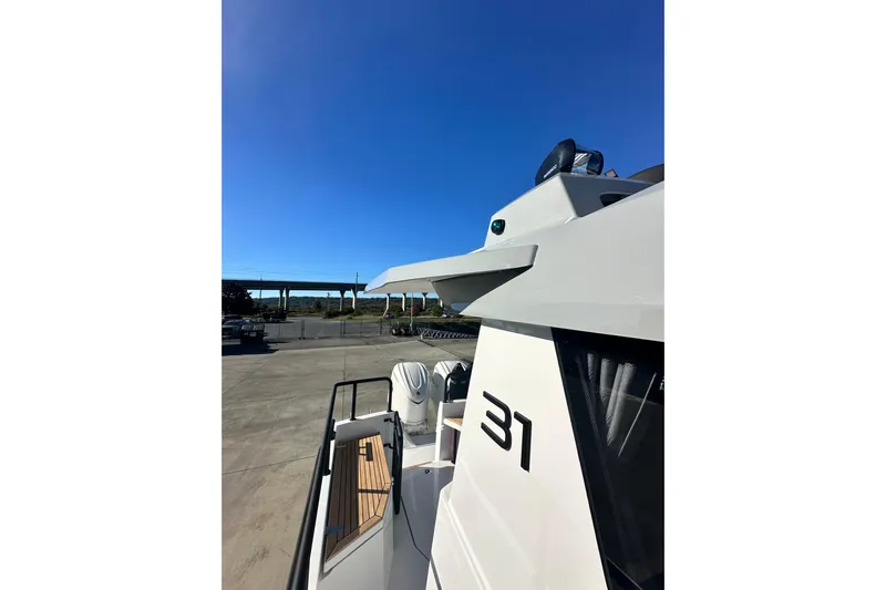  Yacht Photos Pics 2025 Sargo 31OB boat exterior with sleek design under clear blue sky.