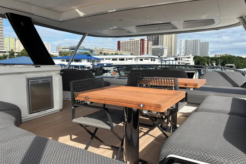 Sixty7 Yacht Photos Pics Luxurious 2023 Lagoon SIXTY 7 yacht deck with modern seating and cityscape view.