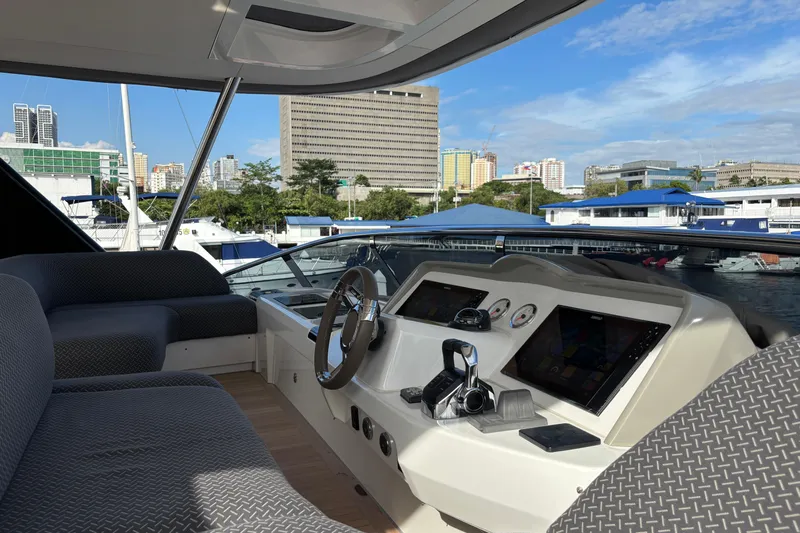 Sixty7 Yacht Photos Pics 2023 Lagoon SIXTY 7 yacht cockpit with modern controls and cityscape background.