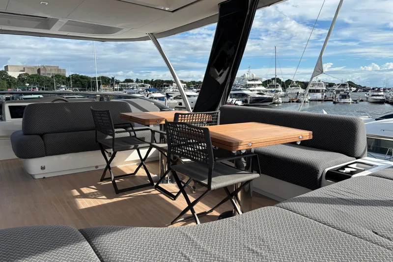 Sixty7 Yacht Photos Pics Luxurious 2023 Lagoon SIXTY 7 yacht deck with seating, tables, and marina view.