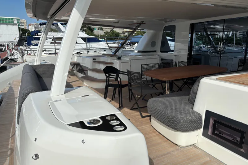 Sixty7 Yacht Photos Pics Luxurious 2023 Lagoon SIXTY 7 yacht deck with seating and dining area at marina.