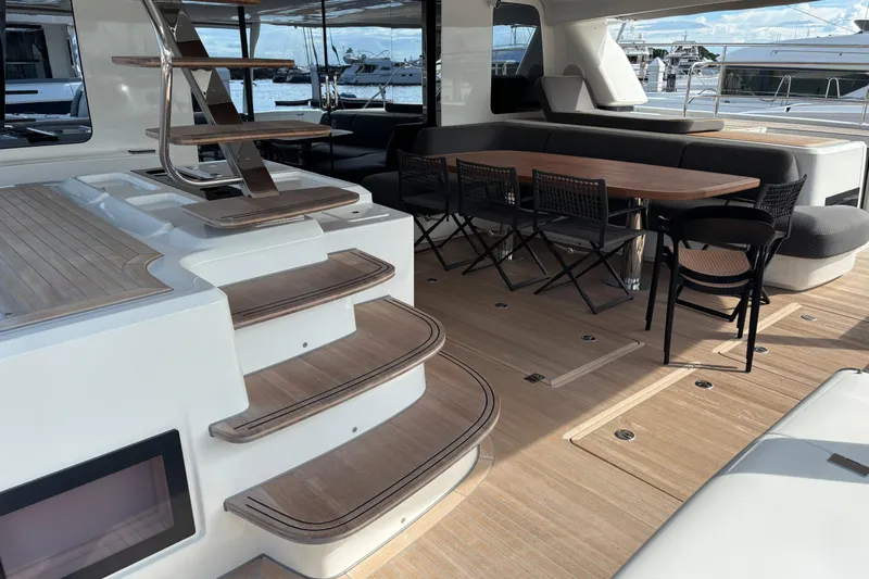 Sixty7 Yacht Photos Pics Luxurious 2023 Lagoon SIXTY 7 yacht interior with elegant seating and wooden staircase.