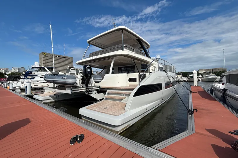 Sixty7 Yacht Photos Pics 2023 Lagoon SIXTY 7 yacht docked at marina under blue sky.
