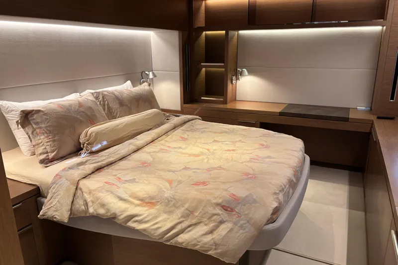 Sixty7 Yacht Photos Pics Luxurious bedroom interior of 2023 Lagoon SIXTY 7 yacht with elegant bedding and wood accents.