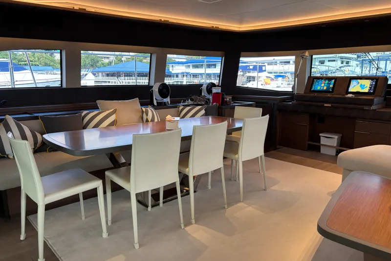 Sixty7 Yacht Photos Pics Luxurious interior of 2023 Lagoon SIXTY 7 yacht with dining area and navigation station.