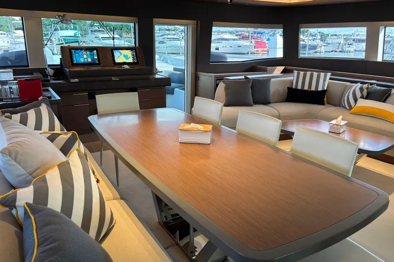 Sixty7 Yacht Photos Pics Luxurious interior of 2023 Lagoon SIXTY 7 yacht with elegant dining area and plush seating.